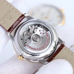 BLS Omega De Ville Collection     Original Mold Master Chronometer This timepiece is crafted from stainless steel, featuring a domed dial treated with deep blue PVD coating. Its surface bears irregular vertical grooves, creating a sunray-brushed finish. Particularly striking are the rhodium-plated hands, Roman numeral hour markers, and alternating cabochon-cut hour indices.A date window is positioned at the 6 o'clock mark, while the dial is adorned with a "railway-track" minute scale, complementing the watch's minimalist aesthetic. It is fitted with a stainless steel bracelet. Clasp type: butterfly clasp. Powered by the Omega 8800 Master Chronometer movement with a black balance wheel, the movement's elegant operation is clearly visible through the scratch-resistant sapphire crystal caseback.